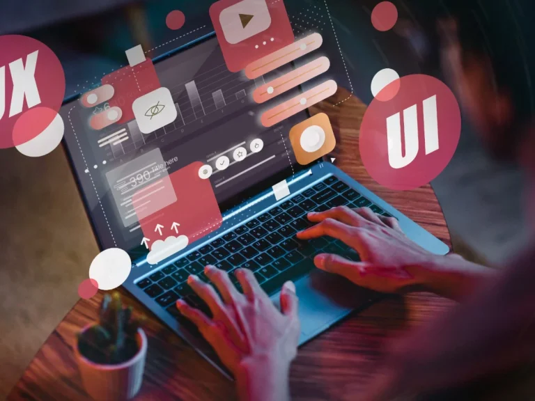 Person tippt auf einem Laptop, umgeben von Symbolen für Design und Multimedia.