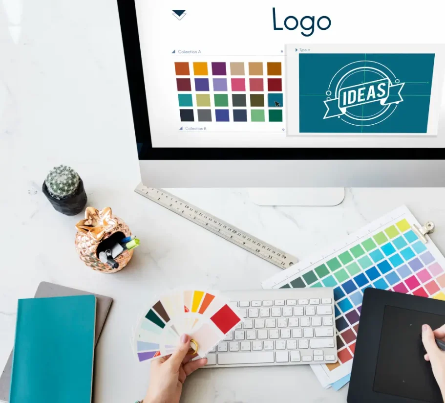 Kreatives Gestalten Schreibtisch mit Farbmustern, Laptop und Laptop, Logo-Design in Arbeit.